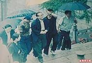 2004年6月4日，江泽民冒雨上九华山参拜地藏菩萨，由两名保镳挟着，神态轻松。
