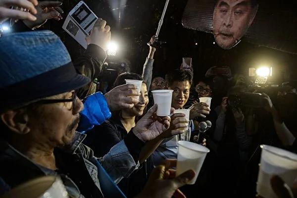 民主派人士游行至礼宾府后,开香槟并高唱《喜气洋洋》,庆祝特首梁振英宣布不竞选连任。(AFP/Getty Images)
